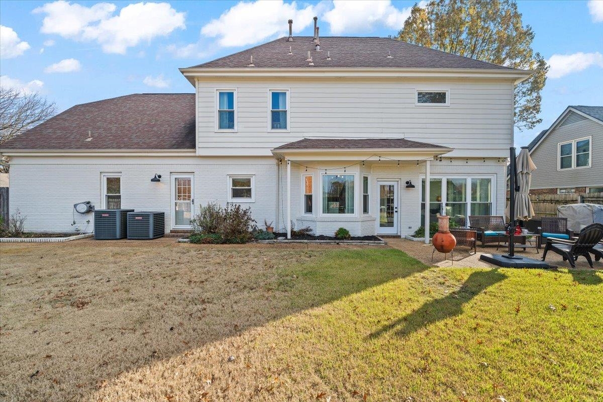 621 Fox Lair Cove Collierville, TN 38017 - Photo 37 of 37 Back of property with a lawn, brick siding, an outdoor living space, a patio area, and roof with shingles
