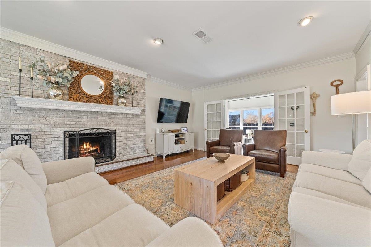 621 Fox Lair Cove Collierville, TN 38017 - Photo 10 of 37 Living area with a fireplace, wood finished floors, and ornamental molding