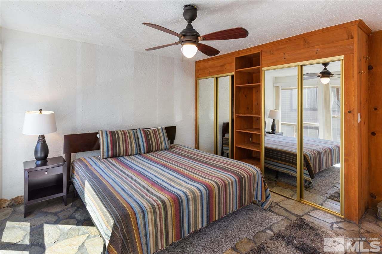 116 B Snowbird Court, Unit B Stateline, NV 89449 - Photo 24 of 40 a bedroom with a bed and a chandelier