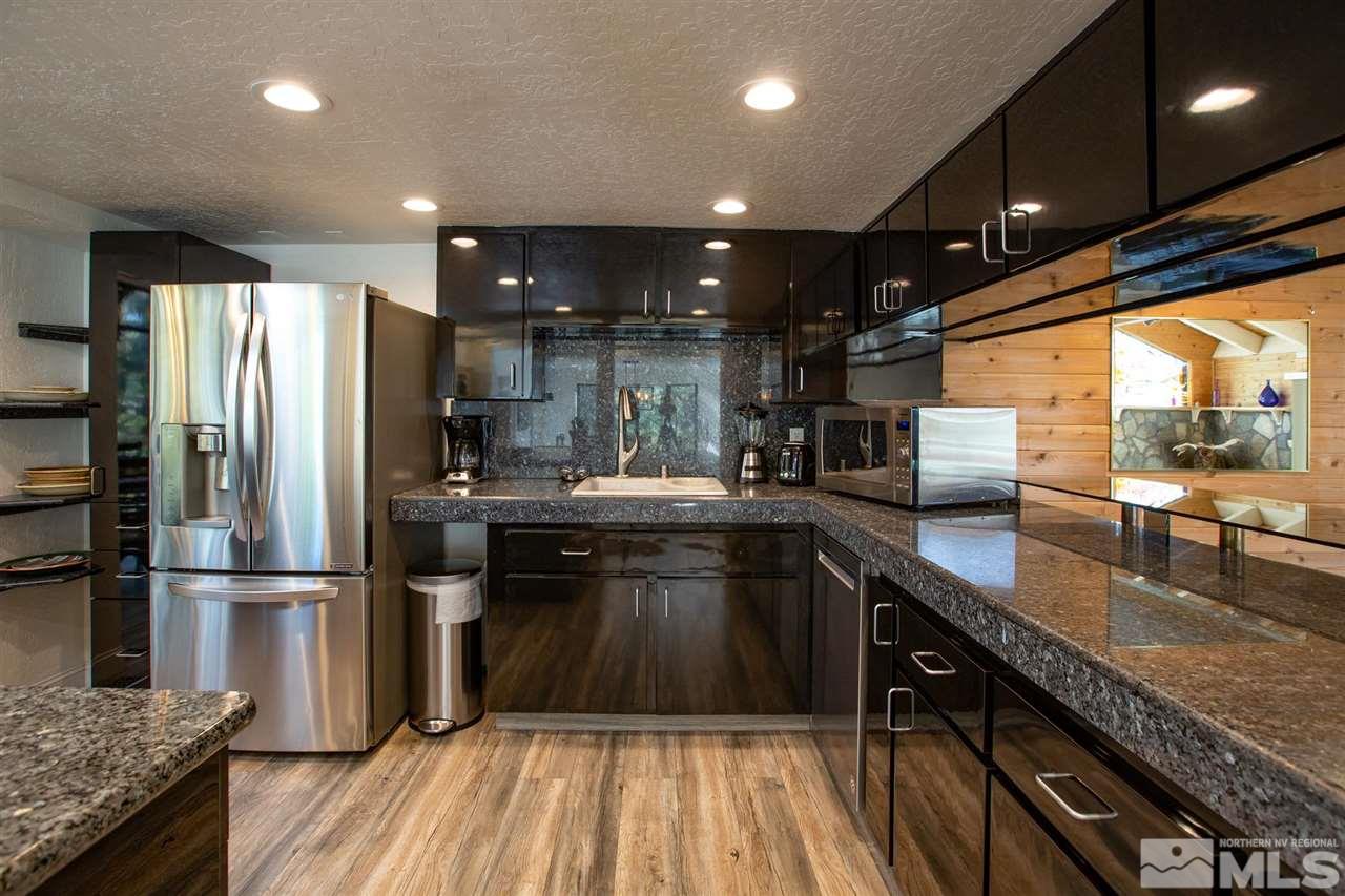 116 B Snowbird Court, Unit B Stateline, NV 89449 - Photo 5 of 40 a kitchen with kitchen island granite countertop a sink appliances and cabinets