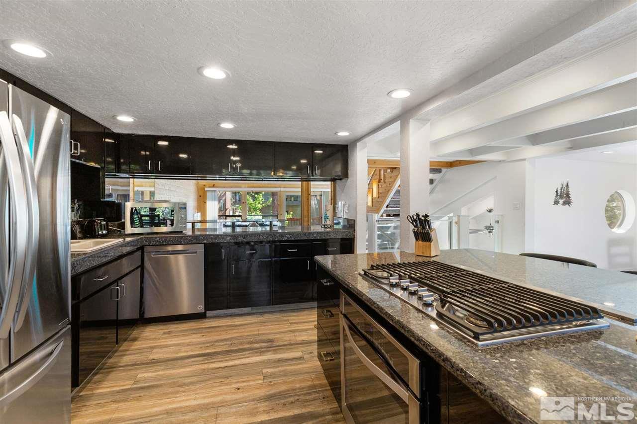 116 B Snowbird Court, Unit B Stateline, NV 89449 - Photo 6 of 40 a kitchen with kitchen island granite countertop a stove and a refrigerator