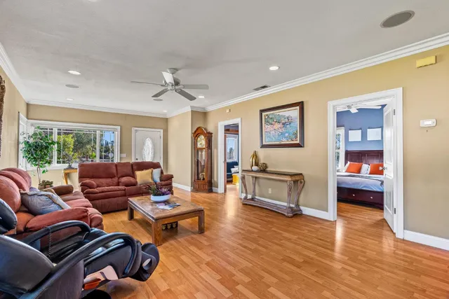 a living room with a couch and a dining table with wooden floor