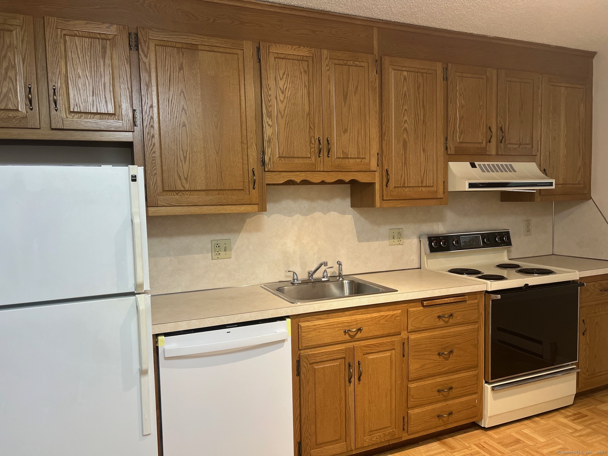 21 Prospect Street, Unit 1 Torrington, CT 06790 - Photo 1 of 13 a kitchen with stainless steel appliances granite countertop a refrigerator a stove and a sink with wooden cabinets