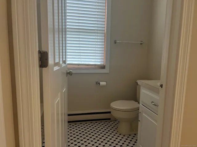 a bathroom with a toilet and a window