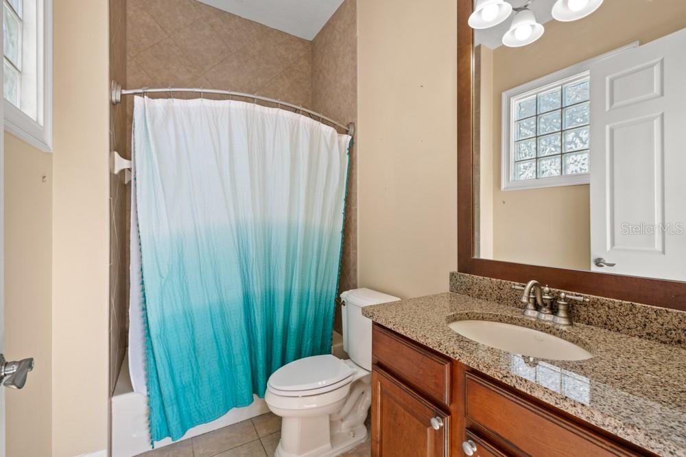 7423 Excitement Drive Reunion, FL 34747 - Photo 24 of 99 a bathroom with a granite countertop sink and a mirror