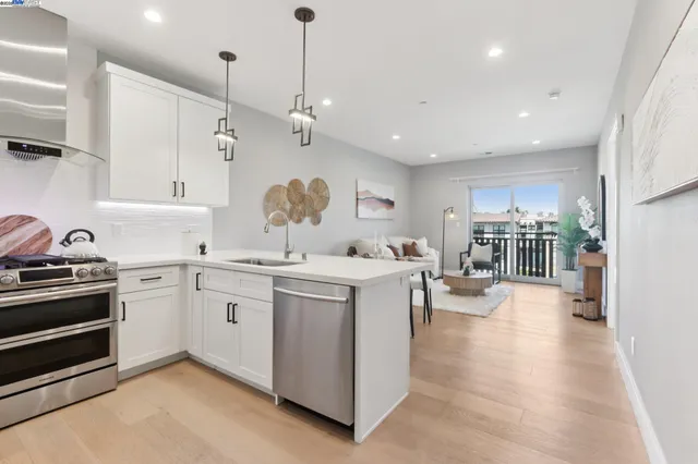 a open kitchen with stainless steel appliances granite countertop a stove oven and a refrigerator with cabinets