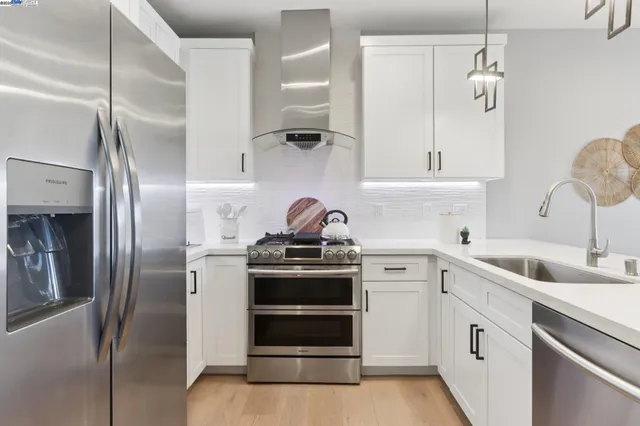 a kitchen with stainless steel appliances a refrigerator sink and cabinets