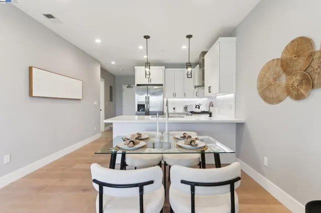 a kitchen with kitchen island stainless steel appliances a table and chairs