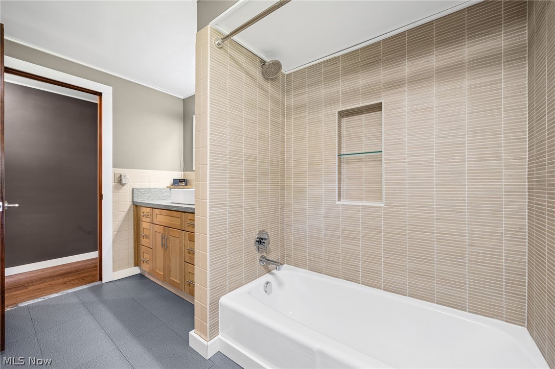 17583 Shurmer Road Strongsville, OH 44136 - Photo 35 of 50 Bathtub shower combination with textured tile surround and recessed niche with glass shelving