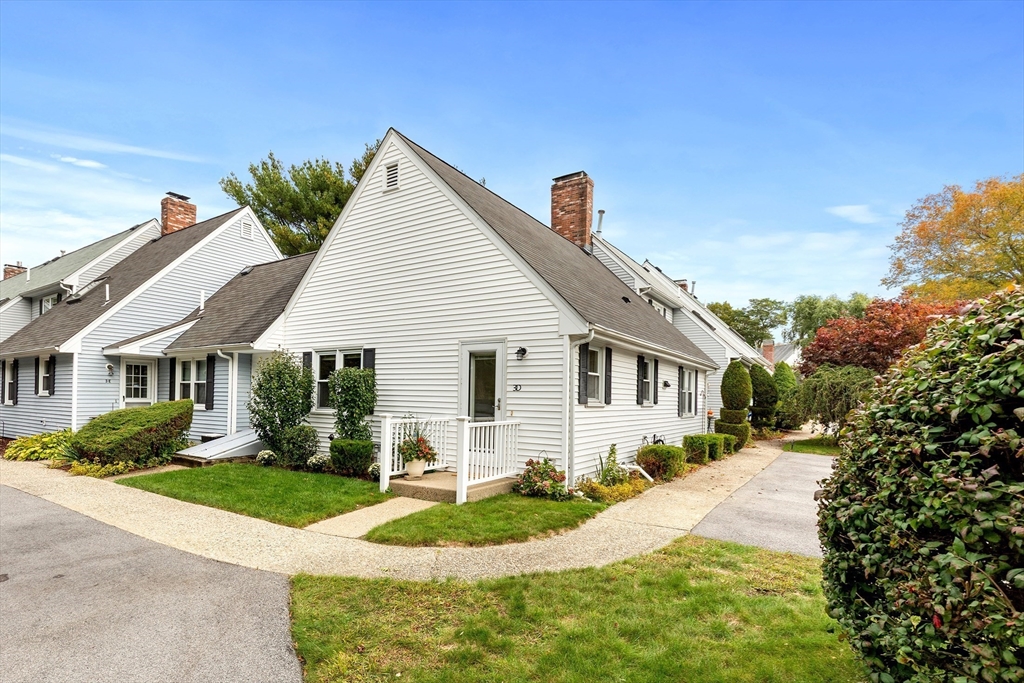 a front view of a house with a yard and potted plants