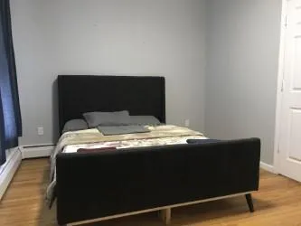 a bed sitting in a bedroom next to a window