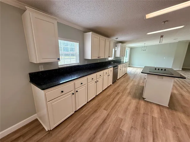 a kitchen with granite countertop a sink and a stove top oven