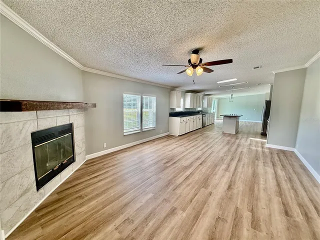 a view of empty room with a fireplace and wooden floor