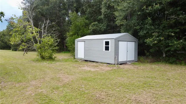 a backyard of a house with plants and tree