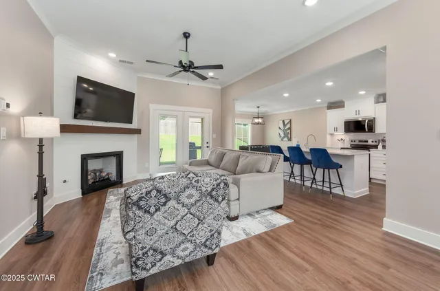 a living room with furniture a flat screen tv and a fireplace