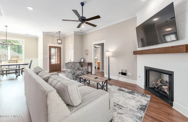 a living room with furniture a flat screen tv and a fireplace