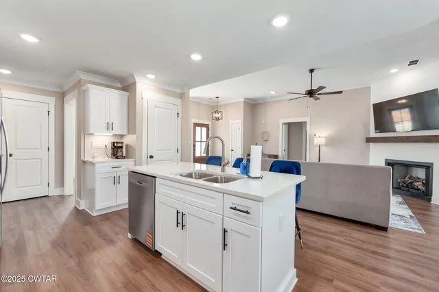 a kitchen with a sink cabinets and wooden floor