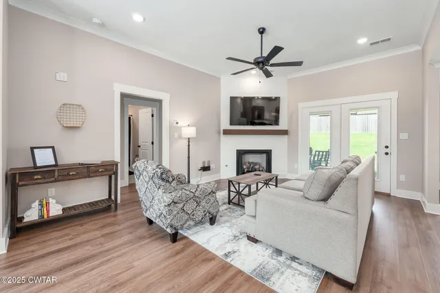 a living room with furniture a fireplace and a flat screen tv