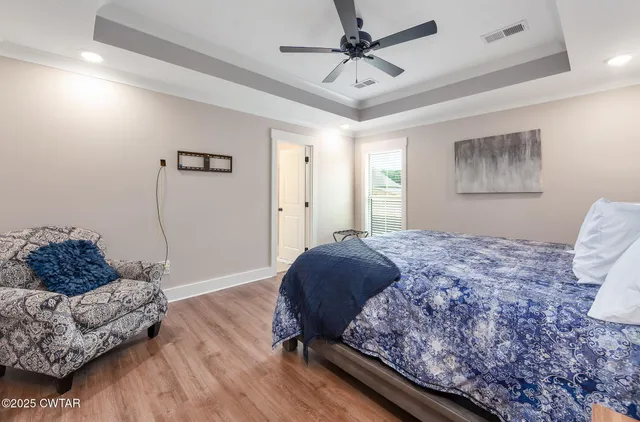 a bedroom with a bed and wooden floor