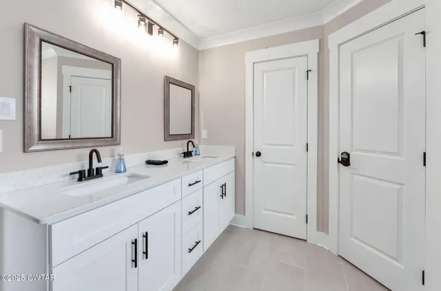 a bathroom with double sink and a mirror