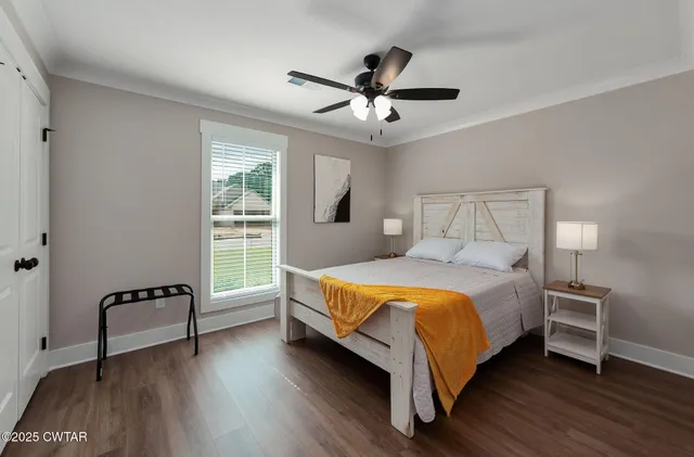 a bed sitting in a bedroom next to a window with a chandelier