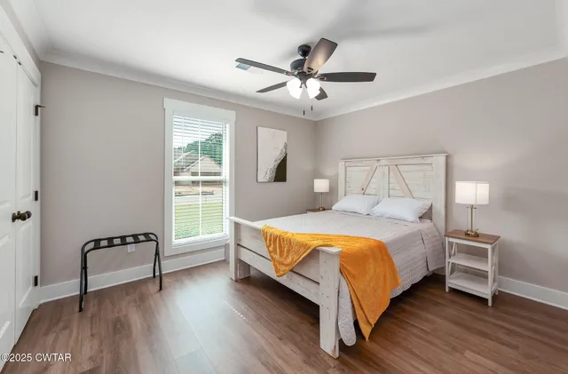 a bed sitting in a bedroom next to a window with a chandelier