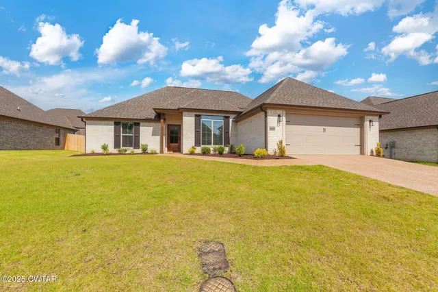 a front view of house with yard and trees