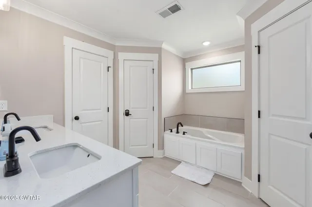 a bathroom with a bathtub a sink and a window