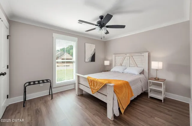a bed sitting in a bedroom next to a window with a chandelier
