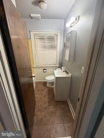 a bathroom with a sink a toilet a mirror and vanity