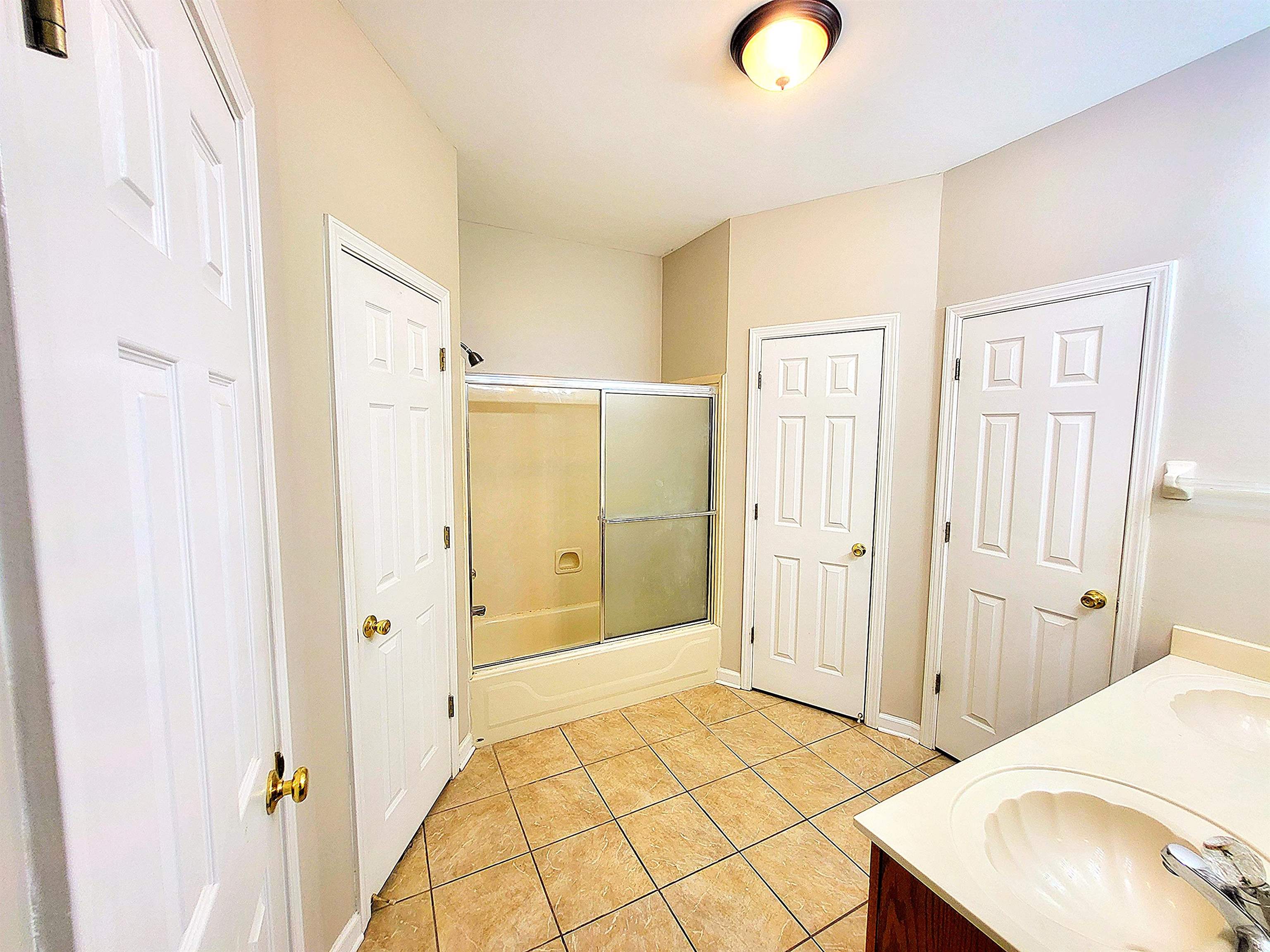 4567 Park Ridge Parkway Collierville, TN 38017 - Photo 14 of 23 Bathroom with tile floors, dual bowl vanity, and shower / bath combination with glass door