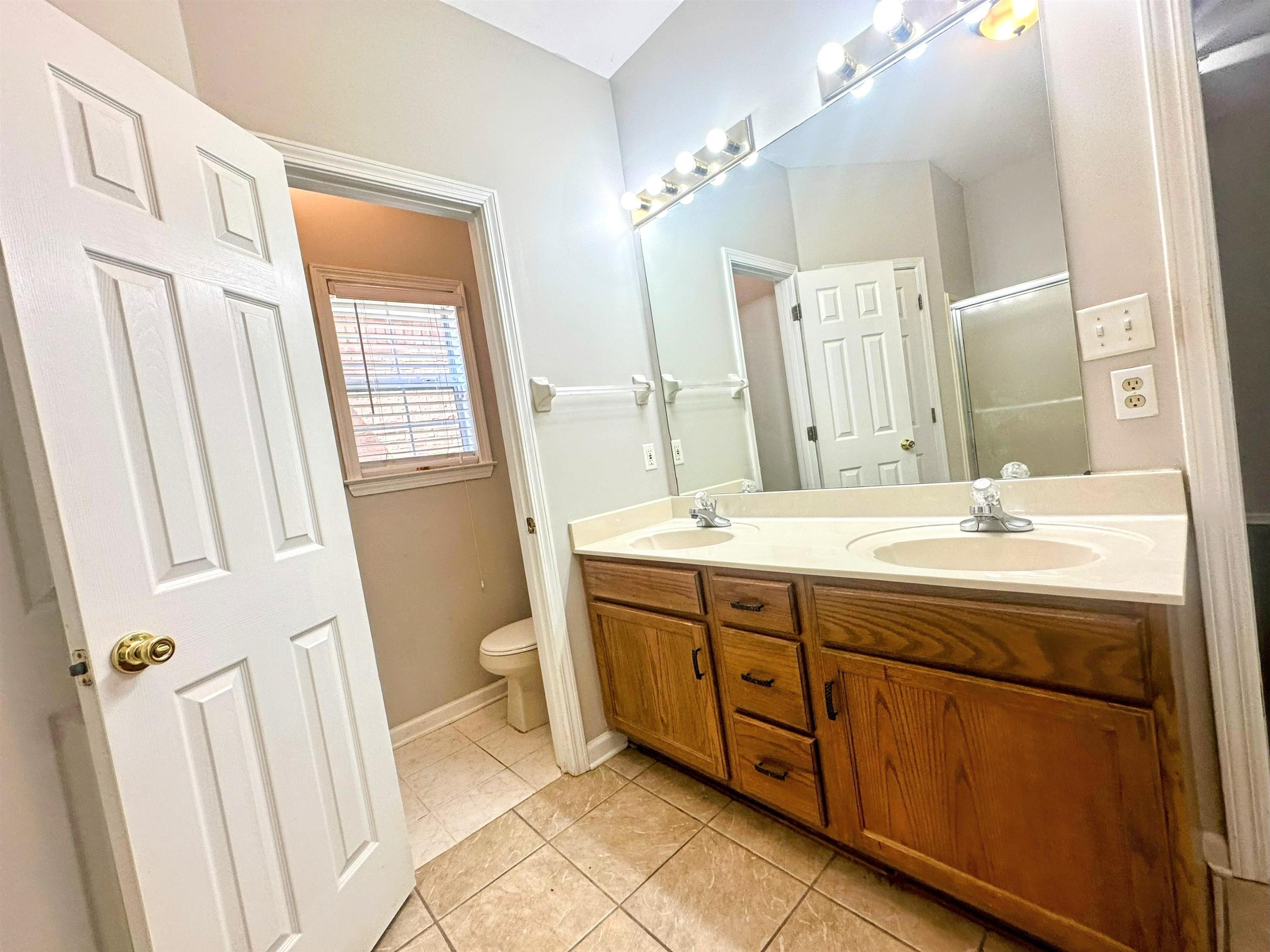 4567 Park Ridge Parkway Collierville, TN 38017 - Photo 15 of 23 Bathroom featuring tile patterned floors, toilet, and dual bowl vanity