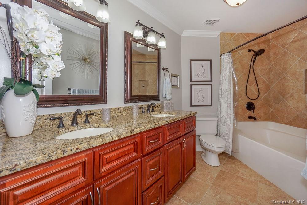 1332 Torrence Circle, Unit 1332 Davidson, NC 28036 - Photo 16 of 24 a bathroom with a granite countertop sink toilet and shower