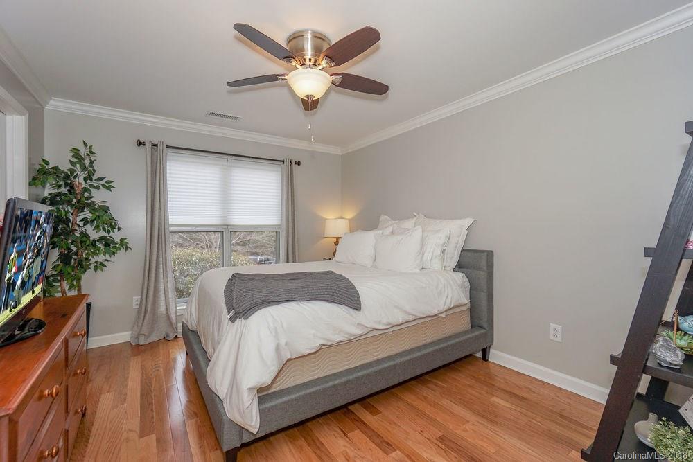 1332 Torrence Circle, Unit 1332 Davidson, NC 28036 - Photo 17 of 24 a bedroom with a large bed and a potted plant