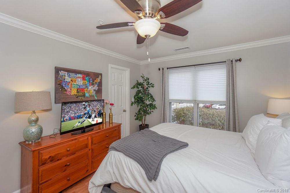 1332 Torrence Circle, Unit 1332 Davidson, NC 28036 - Photo 18 of 24 a bedroom with a bed and a flat screen tv