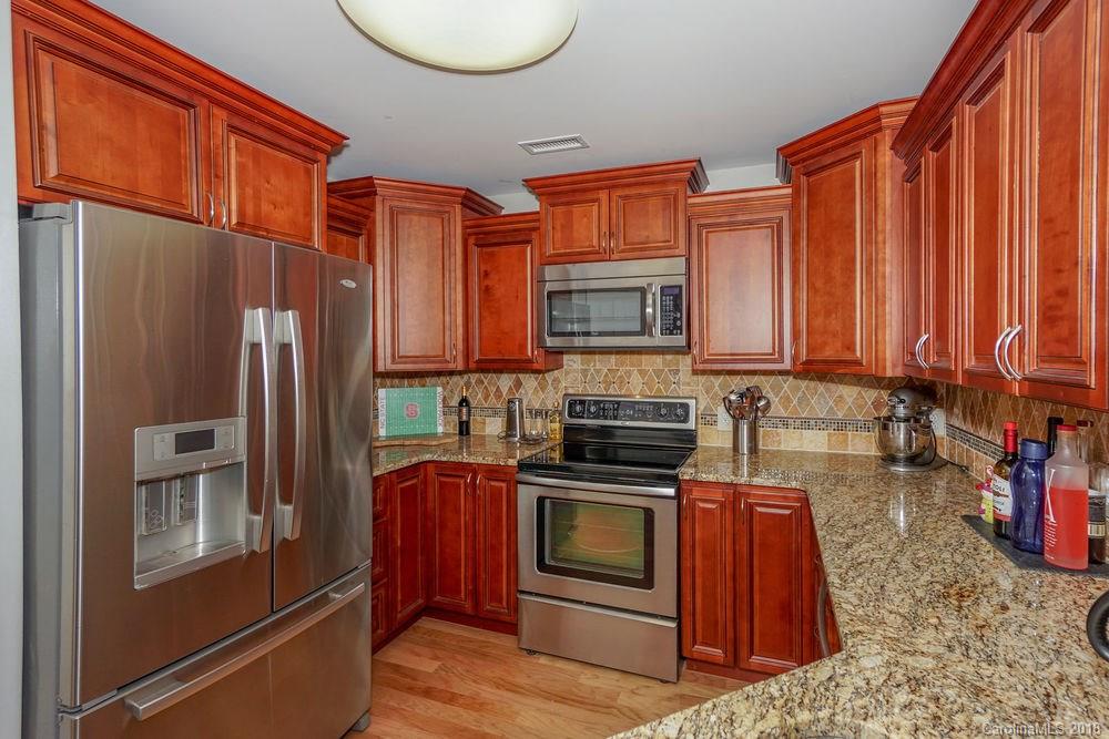 1332 Torrence Circle, Unit 1332 Davidson, NC 28036 - Photo 4 of 24 a kitchen with stainless steel appliances granite countertop a refrigerator a stove a sink and dishwasher