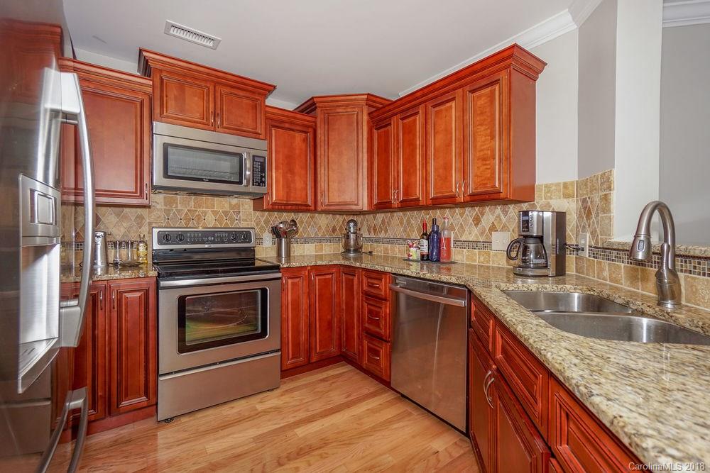 1332 Torrence Circle, Unit 1332 Davidson, NC 28036 - Photo 5 of 24 a kitchen with stainless steel appliances granite countertop a sink stove and microwave