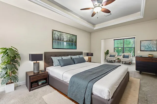 a spacious bedroom with a bed and a chandelier
