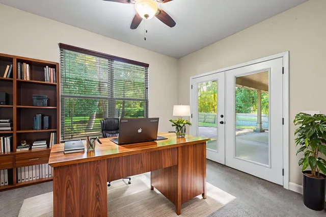 a view of a workspace with furniture and a window