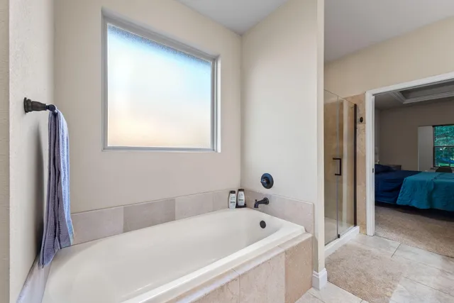 a bathroom with a tub a sink and a window