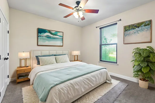 a bedroom with bed and a painting on the wall