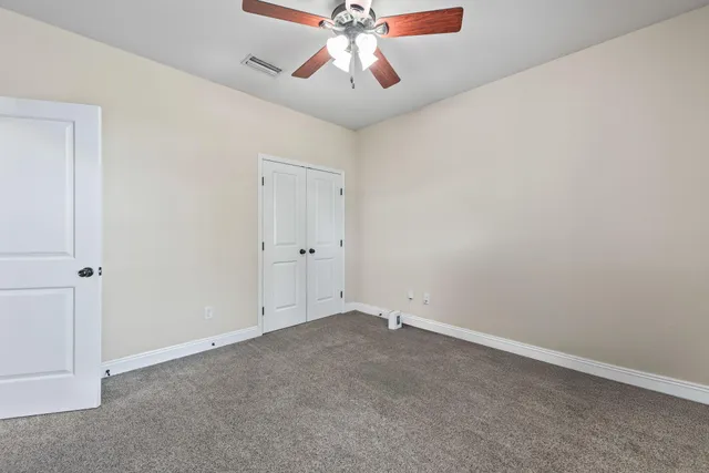 an empty room with chandelier fan