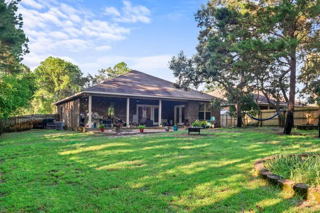 a front view of a house with a garden and trees