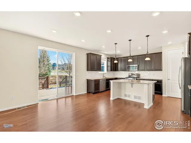 a large white kitchen with lots of counter space a sink and appliances