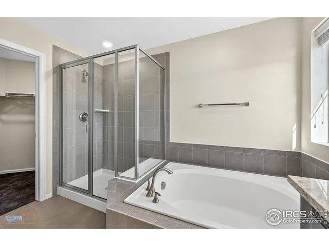 a bathroom with a tub a mirror and a shower