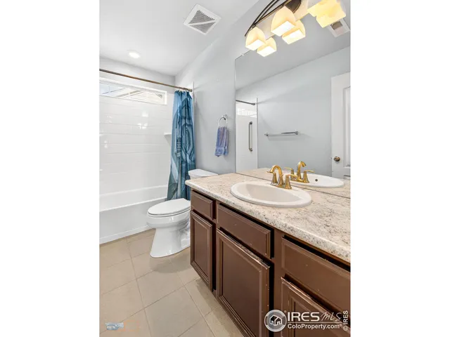 a bathroom with a granite countertop sink a toilet and a mirror