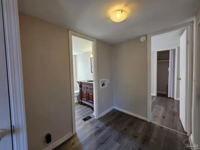 a view of empty room with wooden floor