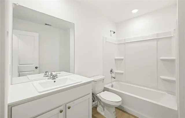 a bathroom with a sink a toilet a mirror and shower