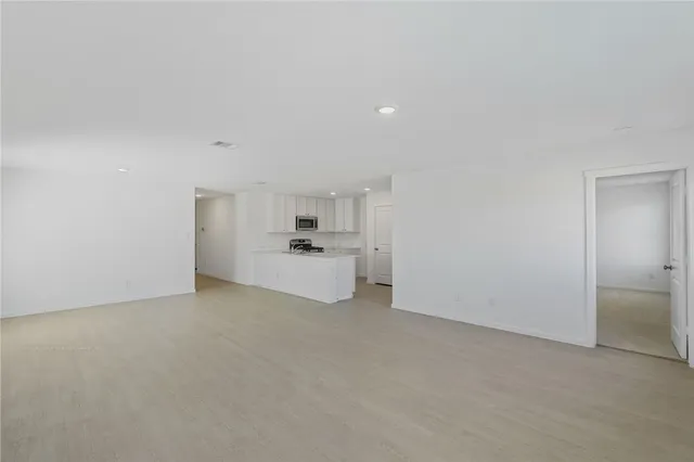 a view of a kitchen with white cabinets and refrigerator