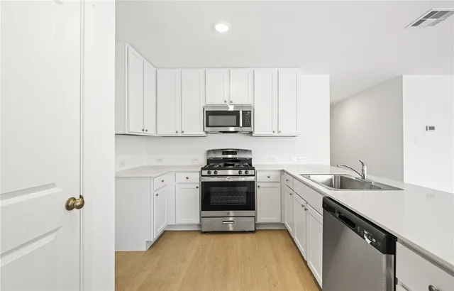 a kitchen with a sink stove and cabinets